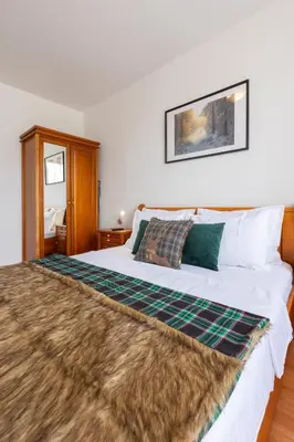 a bedroom with a large bed with a blanket on it at Alpine Escape Bansko in Bansko