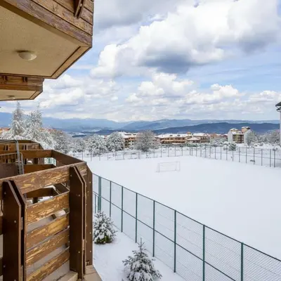 a snow covered balcony with a view of the mountains at Alpine Escape Bansko in Bansko