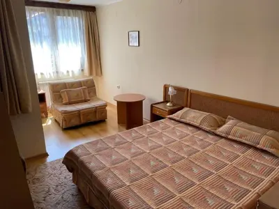 a bedroom with a bed and a chair and a window at Kalaydzhiev Guest House - Къща с 5 спални in Bansko