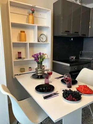 a kitchen with a table with two glasses of wine at Rea Liliya - Artistic and Inviting Nook in Sofia