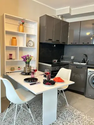 a kitchen with a table with two glasses of wine at Rea Liliya - Artistic and Inviting Nook in Sofia
