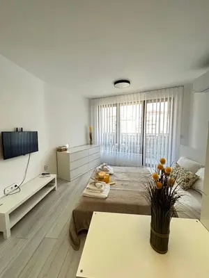 a white room with a bed and a table with oranges on it at Rea Silena - Modern and Stylish Studio in Sofia