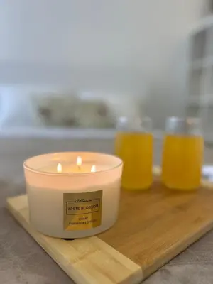 a candle on a cutting board with two glasses of orange juice at Rea Silena - Modern and Stylish Studio in Sofia