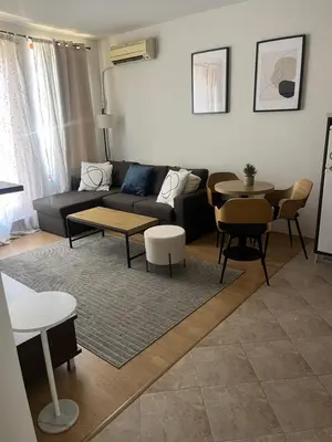 a living room with a couch and a table and chairs at Guest House Amaya by novotela in Plovdiv