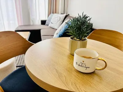 a coffee cup sitting on a wooden table with a plant at Guest House Amaya by novotela in Plovdiv