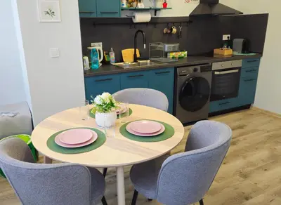 a kitchen with a table with pink plates and chairs at Stylish 2-Bedroom Apartment in Top Center - 5m walk to Metro station Serdika, Sofia statue -- 1 FullBath & 1Washroom in Sofia