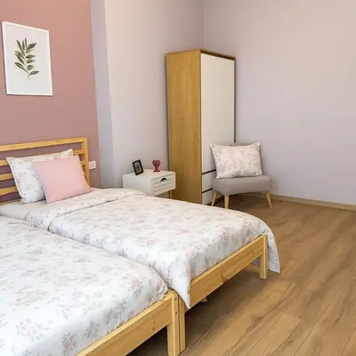 a bedroom with two beds and a chair at Stylish 2-Bedroom Apartment in Top Center - 5m walk to Metro station Serdika, Sofia statue -- 1 FullBath & 1Washroom in Sofia