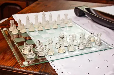 a glass chess board with chess pieces on a table at Дедовата Къща in Dedovo