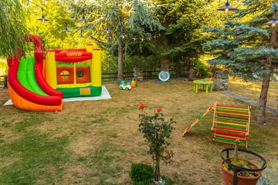 a playground with a slide in a yard at Дедовата Къща in Dedovo