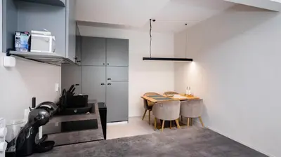 a kitchen with a table and chairs in a room at Cosy & Modern 1BD Flat close to NDK by Flat Mаnager in Sofia