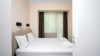 a white bed in a room with a window at Cosy & Modern 1BD Flat close to NDK by Flat Mаnager in Sofia