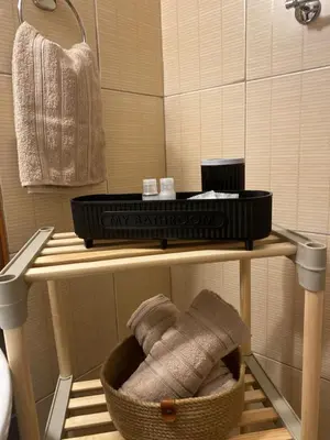 a bathroom with a shelf with a basket of towels at Barosa Apartment Bansko Royal Towers in Bansko