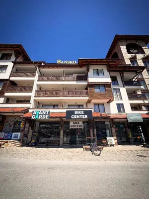 a large building with a bike center in front of it at Barosa Apartment Bansko Royal Towers in Bansko