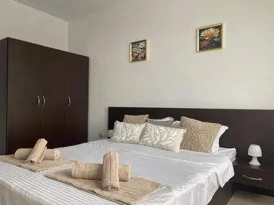 a bedroom with a large bed with two towels on it at Barosa Apartment Bansko Royal Towers in Bansko