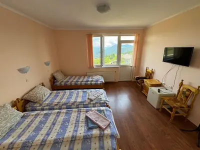 a bedroom with two beds and a flat screen tv at Guest House Chala in Chala