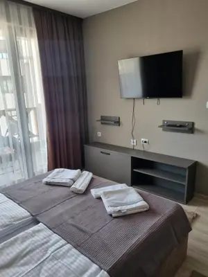 a hotel room with a bed with two towels on it at Apartament Rumqncev in Velingrad
