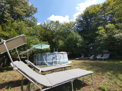 a group of chairs and an umbrella on a yard at Къща за гости Аврамови in Ribarica
