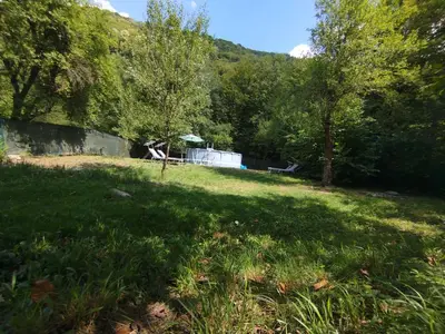 a view of a yard with trees and a building at Къща за гости Аврамови in Ribarica