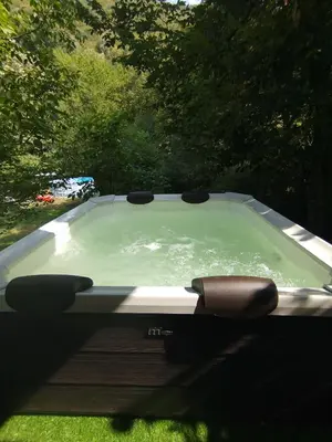 a swimming pool with a chair in the grass at Къща за гости Аврамови in Ribarica
