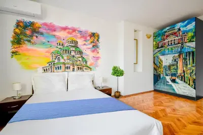 a bedroom with a white bed and a painting on the wall at Spacious 3BR in the Center - Kitchen Smart TV's in Sofia