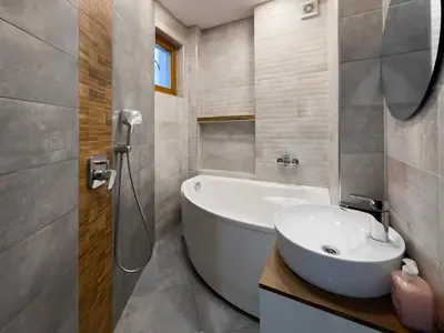 a bathroom with a white tub and a sink at Spacious 3BR in the Center - Kitchen Smart TV's in Sofia