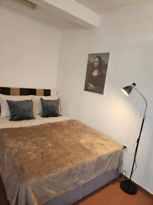 a bedroom with a bed with a lamp and a picture at Charming Ground Floor Aprt In Old Sofia in Sofia