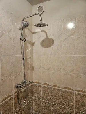 a shower with a shower head in a bathroom at Charming Ground Floor Aprt In Old Sofia in Sofia