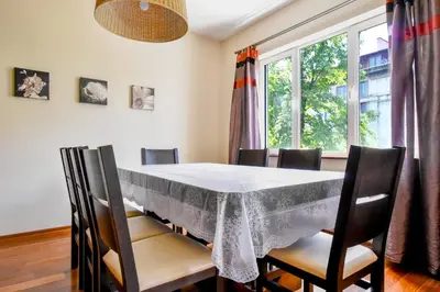 a dining room with a table and chairs and a window at Modern 2BD Flat in Central Sofia with Workspace by Flat Mаnager in Sofia