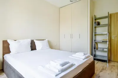 a bedroom with a white bed with towels on it at Modern 2BD Flat in Central Sofia with Workspace by Flat Mаnager in Sofia