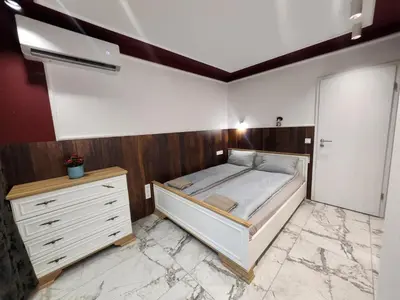 a bedroom with a bed and a dresser at Luxury Continental two rooms in Sofia