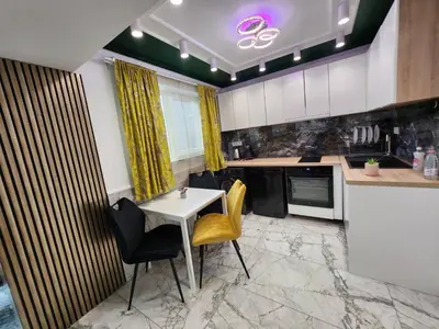 a kitchen with a table and yellow chairs in it at Luxury Continental two rooms in Sofia