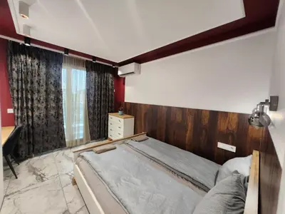 a bedroom with a bed with a wooden headboard at Luxury Continental two rooms in Sofia