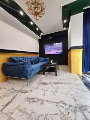 a living room with a blue couch and a tv at Luxury Continental two rooms in Sofia
