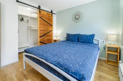 a bedroom with a bed with a blue comforter at Charming Downtown Apartment with Unique Terrace in Sofia