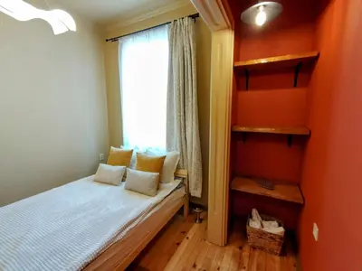 a small bedroom with a bed and a window at Moon House Red in Plovdiv