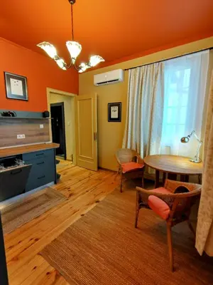 a living room with orange walls and a table and chairs at Moon House Red in Plovdiv