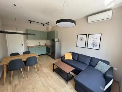a living room with a blue couch and a table at By The River in Plovdiv