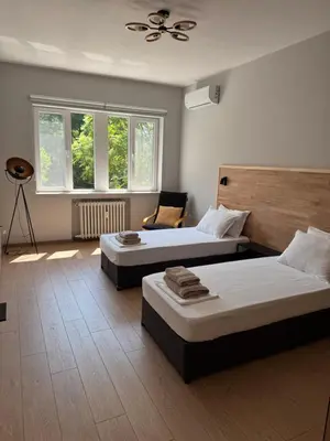 a bedroom with two beds and a fan at By The River in Plovdiv