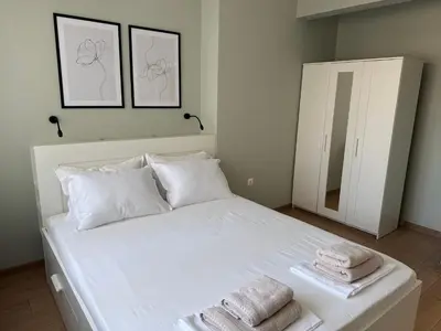 a bedroom with a white bed with towels on it at By The River in Plovdiv