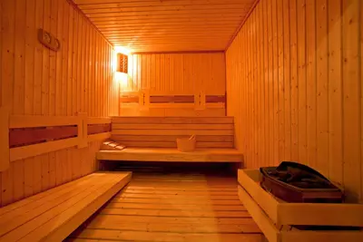 a sauna with a bench in a wooden room at Hotel Coop Rozhen in Pamporovo