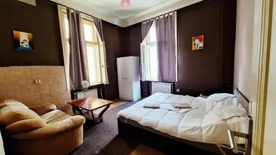 a bedroom with a large bed and a chair in it at Key Hostel Vitosha in Sofia