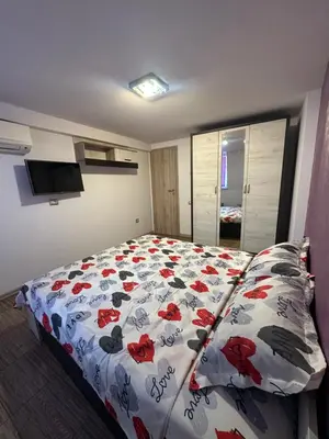 a bedroom with a bed with red flowers on it at Guest Rooms Comfort 2 in Plovdiv