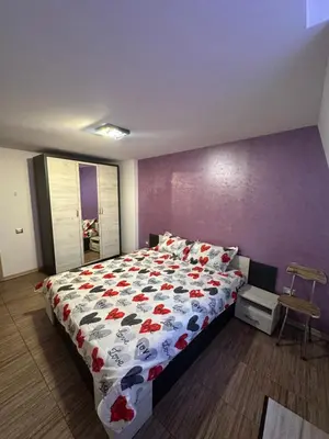 a bedroom with a bed with a floral comforter at Guest Rooms Comfort 2 in Plovdiv