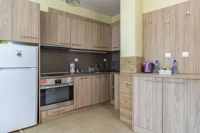 a kitchen with wooden cabinets and a white refrigerator at My Space Deluxe One Bedroom Apartment in Sofia