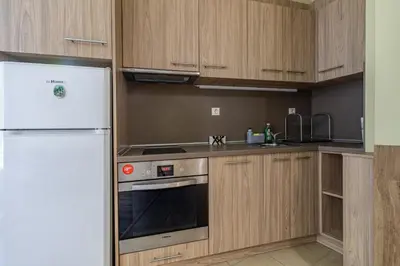 a kitchen with a white refrigerator and wooden cabinets at My Space Deluxe One Bedroom Apartment in Sofia