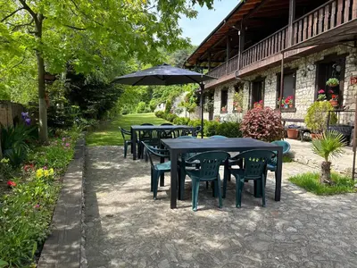a group of tables and chairs with an umbrella at Къща за гости Лясково in Lyaskovo