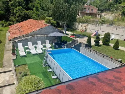 an overhead view of a swimming pool with chairs and an umbrella at Къща за гости Лясково in Lyaskovo