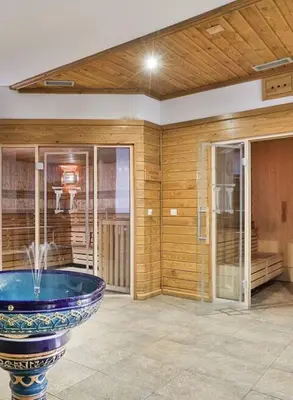 a large room with a tub in the center of a house at Pirin Golf Spa Condo with Mountain View in Razlog