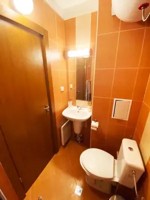 a bathroom with a toilet and a sink at Pirin Golf Spa Condo with Mountain View in Razlog