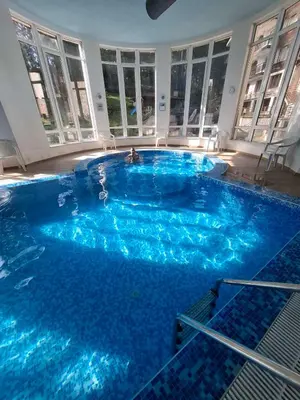 a large pool with blue water in a building at Pine forest apartments in Pamporovo